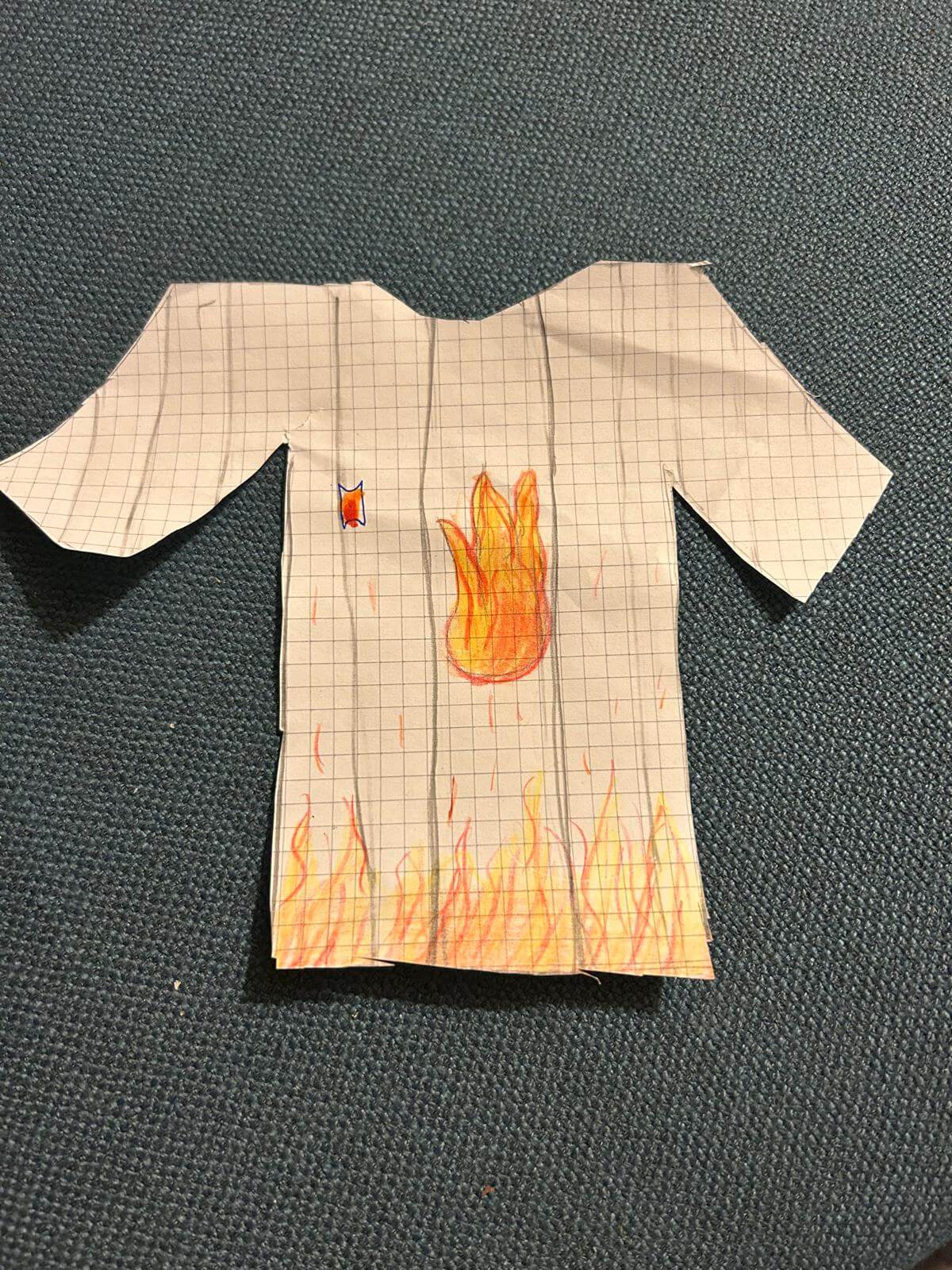 Hand-drawn football kit sketch on grid paper by a young player