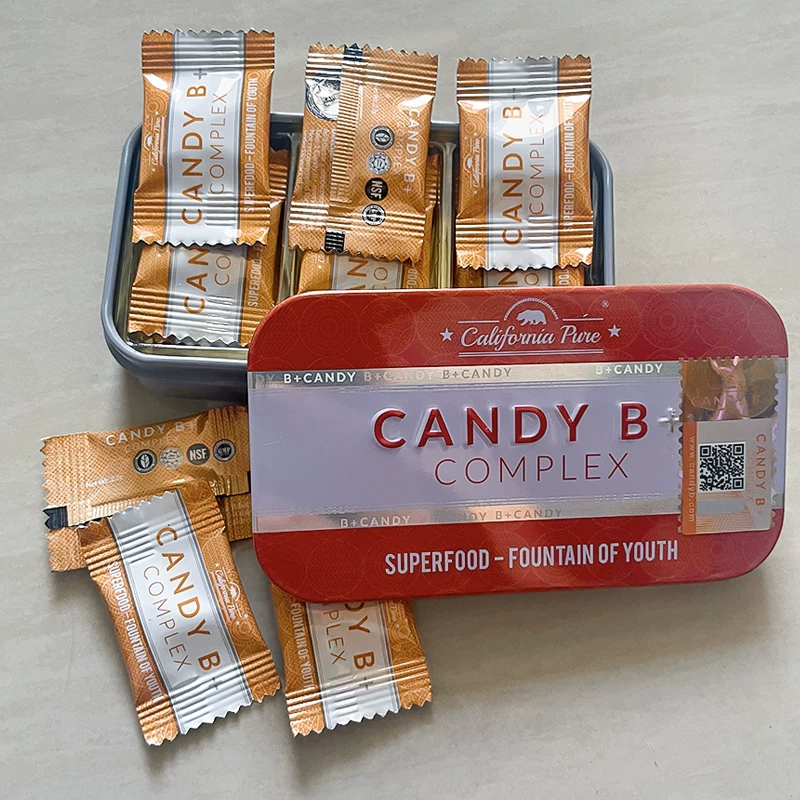 Candy B Complex packets arranged around a red and silver storage tin