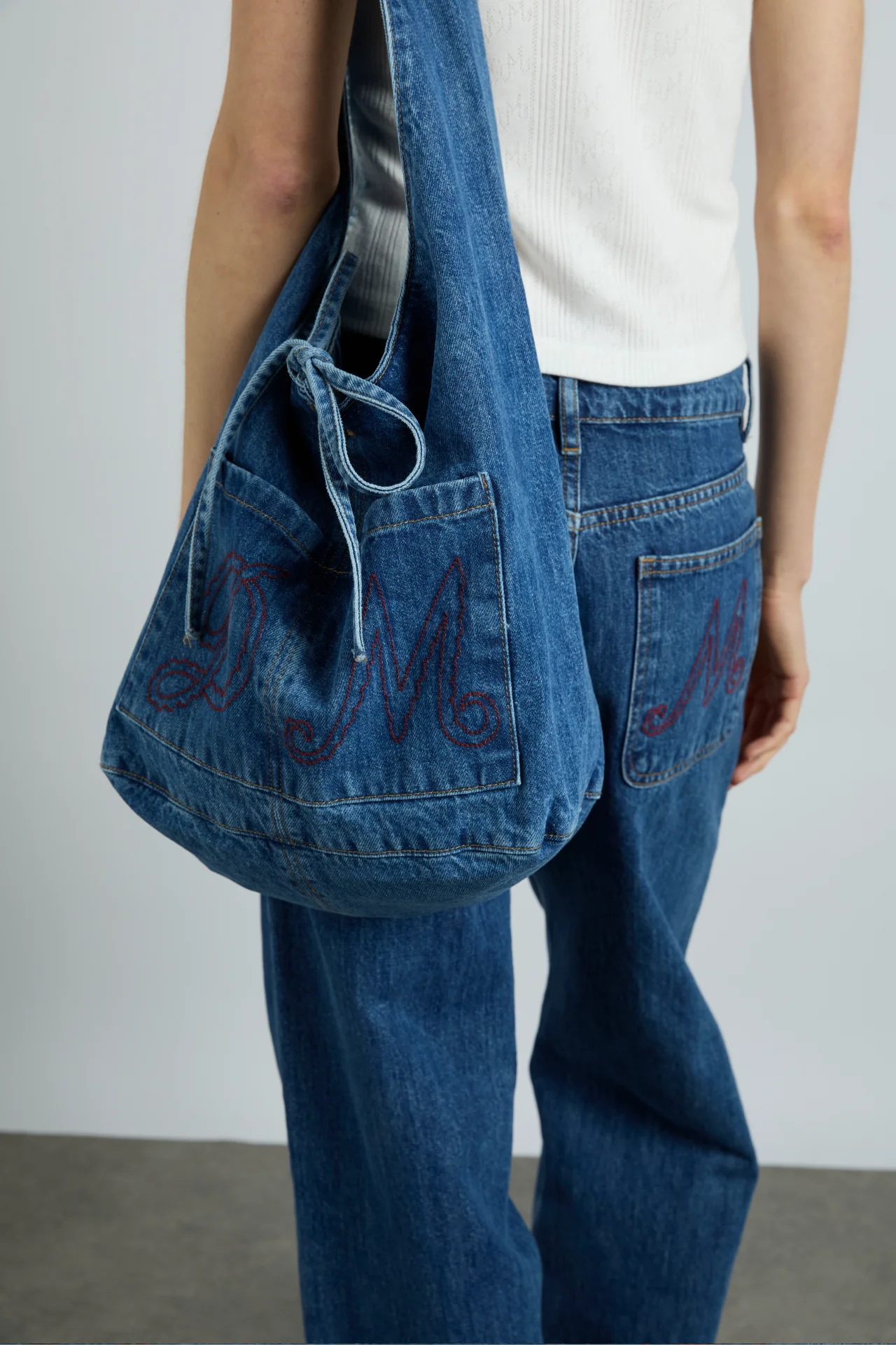 denim sling bag with pocket detail