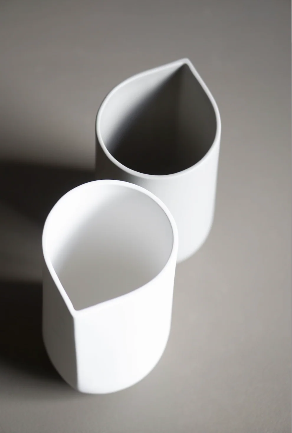 dbkd Vase Nib: eine Vase mit einer ungewöhnlichen Form in weiß und grau