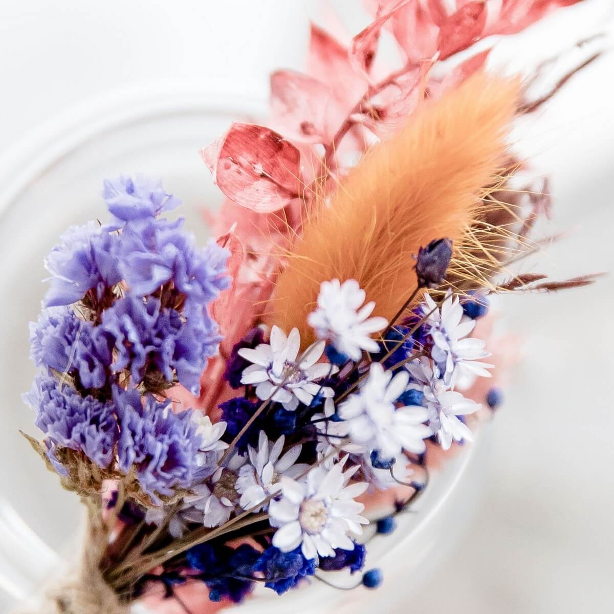 aparter Anstecker: Trockenblumen in einer Kombination aus Blau- und Orangetönen