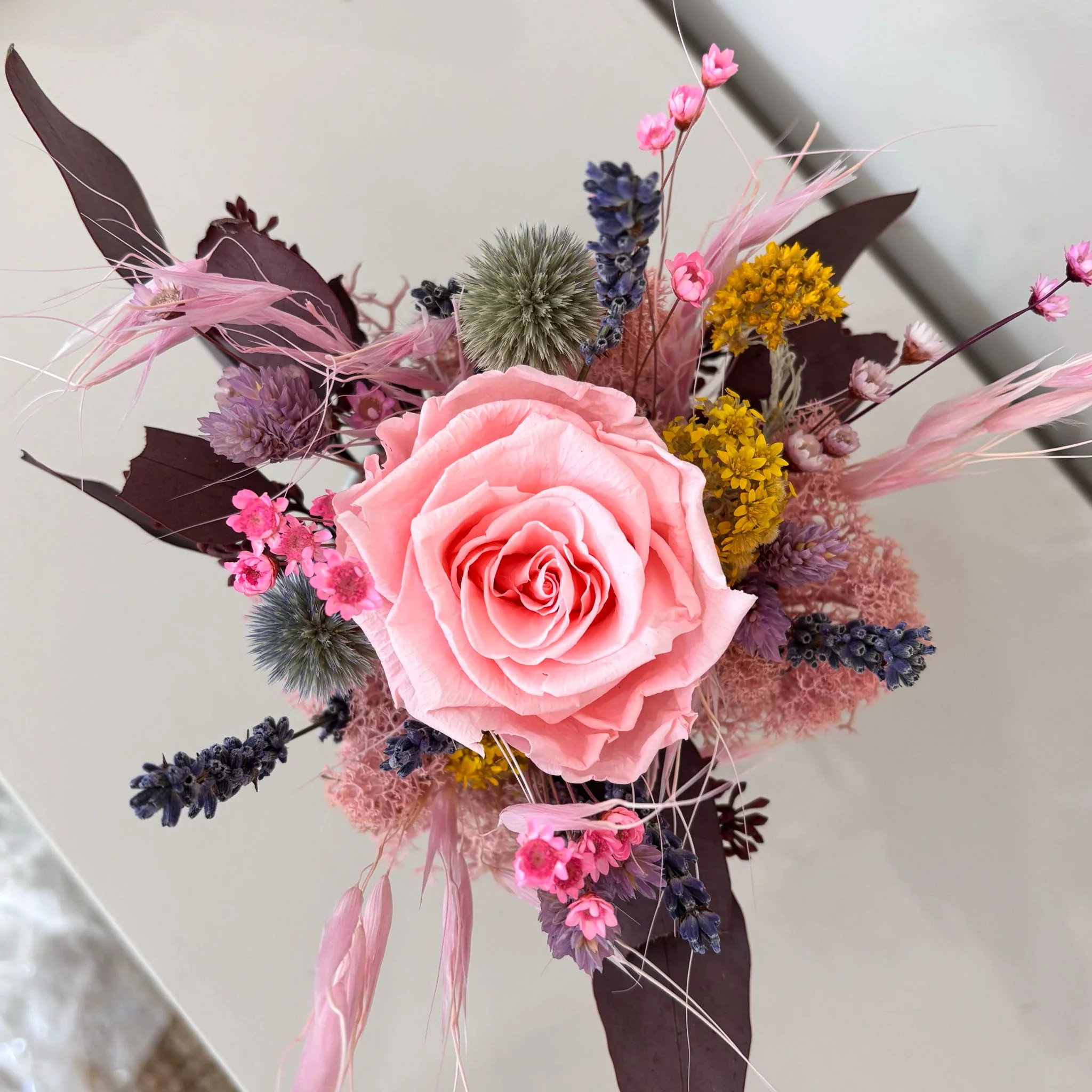 Fröhliches Gesteck mit Rose in Herz Becher