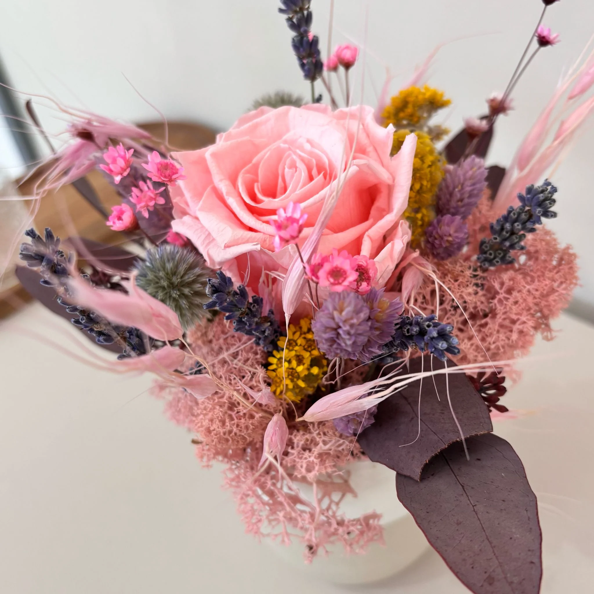 Fröhliches Gesteck mit Rose in Herz Becher