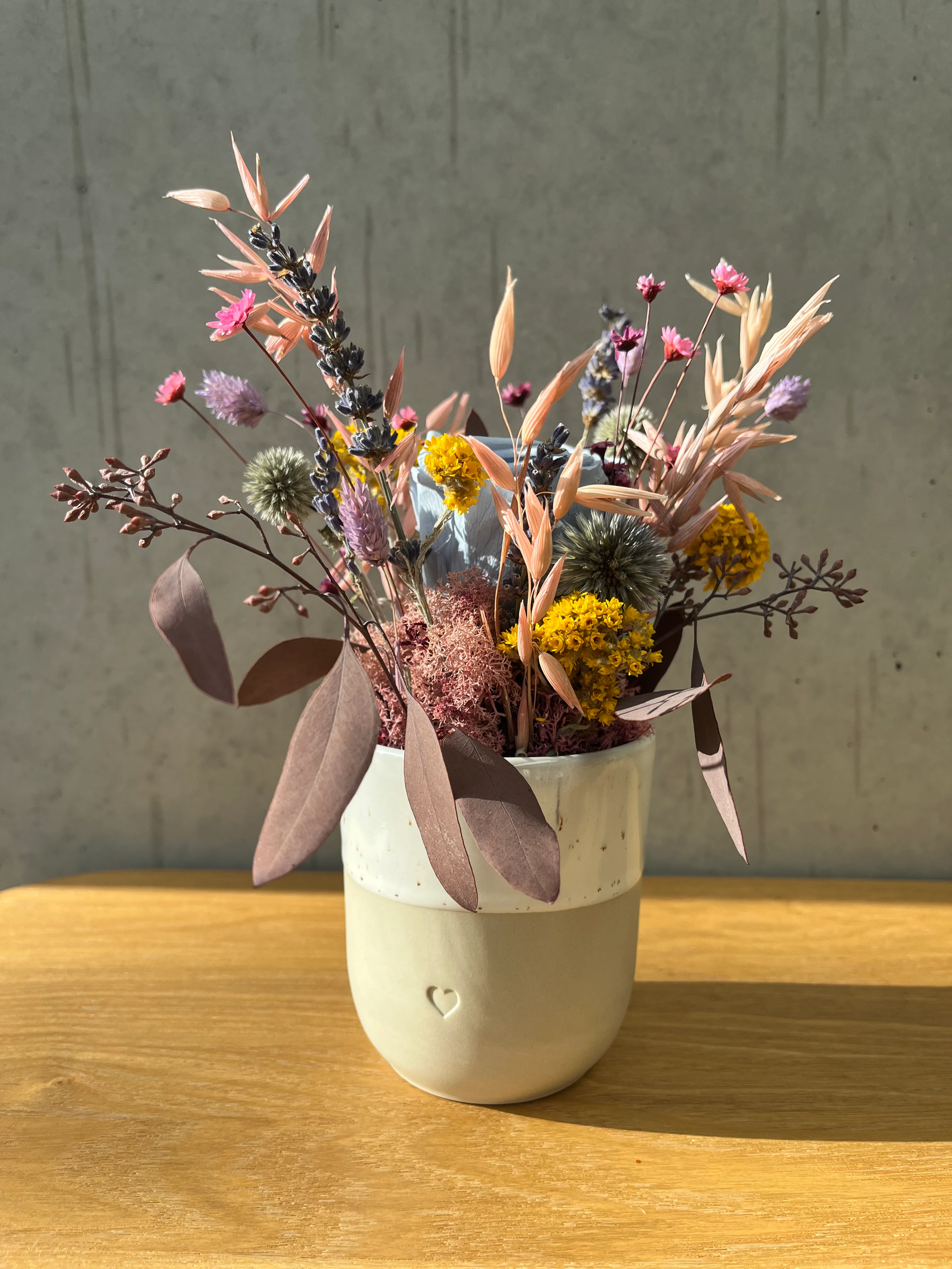 Fröhliches Gesteck mit Rose in Herz Becher