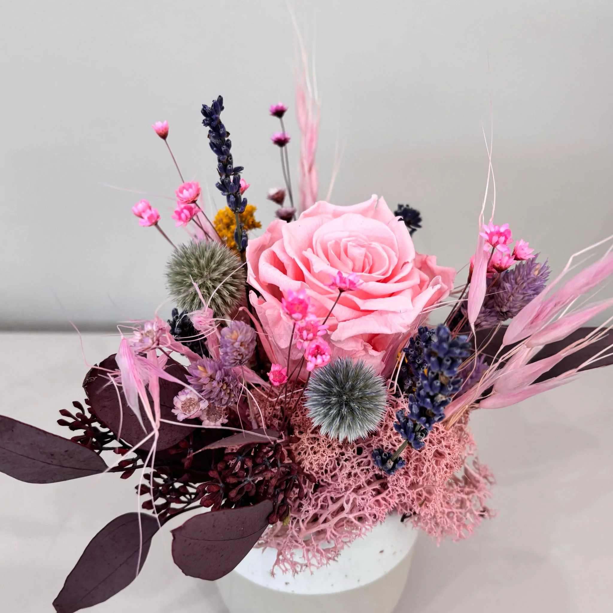 Fröhliches Gesteck mit Rose in Herz Becher