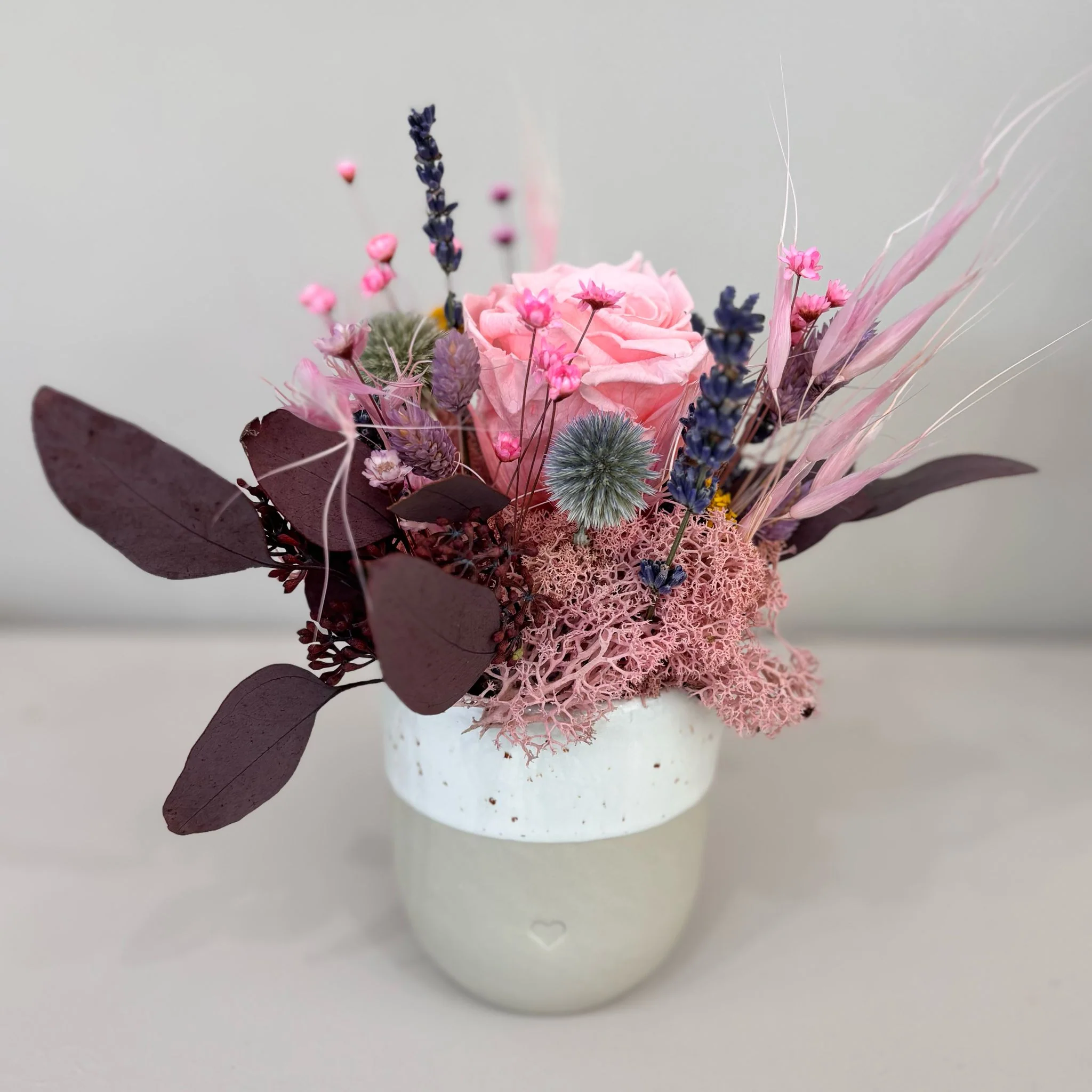 Fröhliches Gesteck mit Rose in Herz Becher