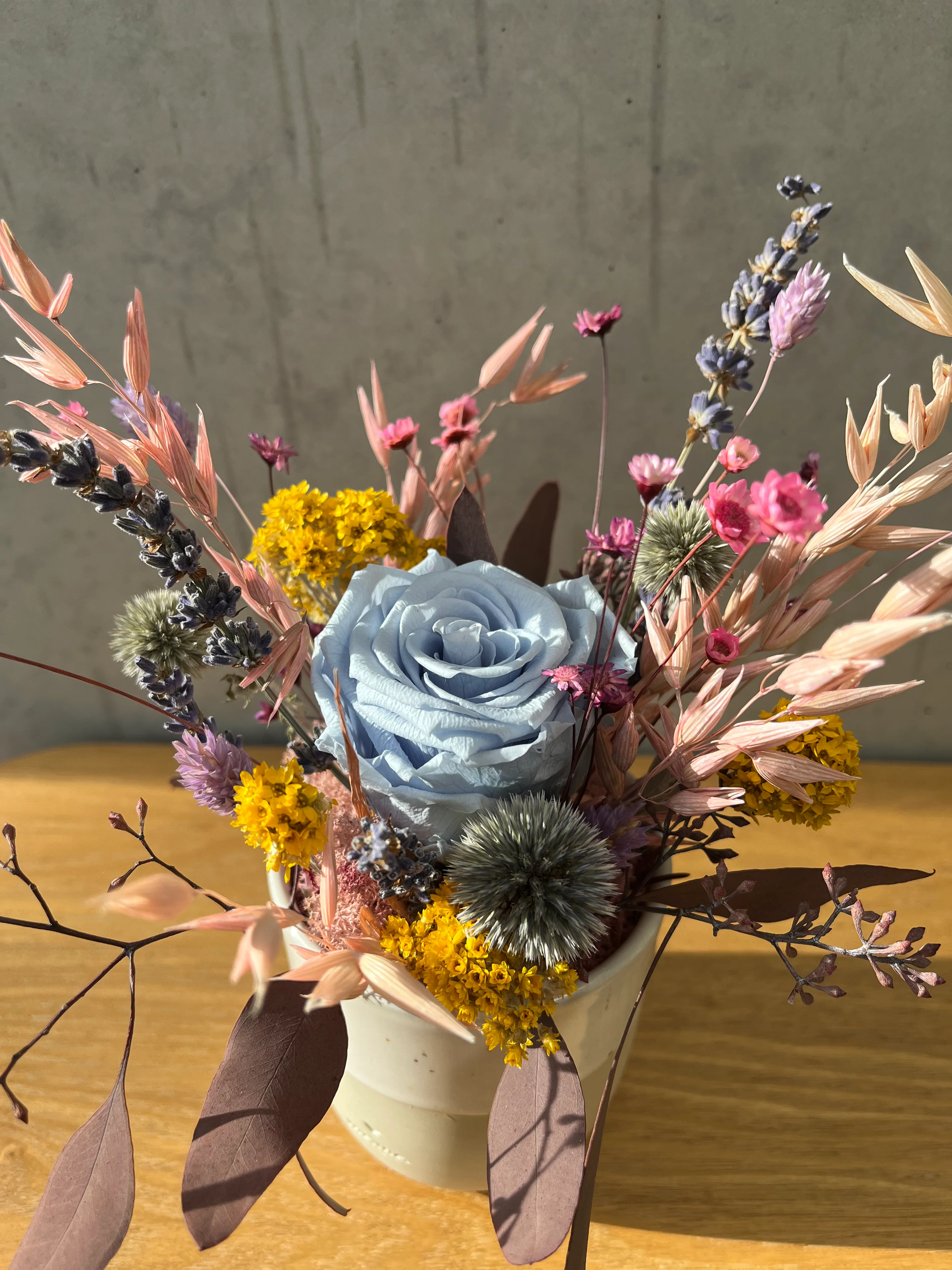 Fröhliches Gesteck mit Rose in Herz Becher