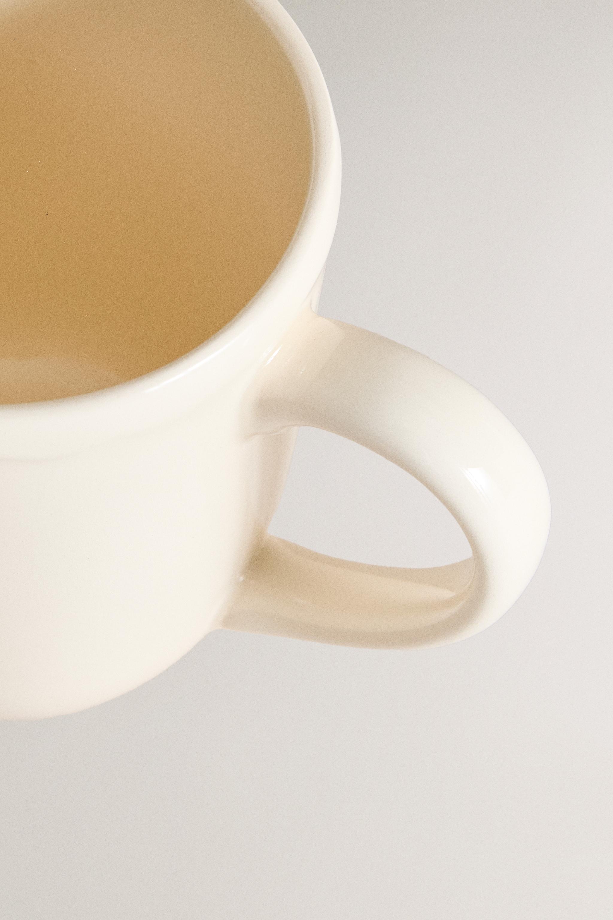 EARTHENWARE MUG WITH A RAISED-DESIGN EDGE